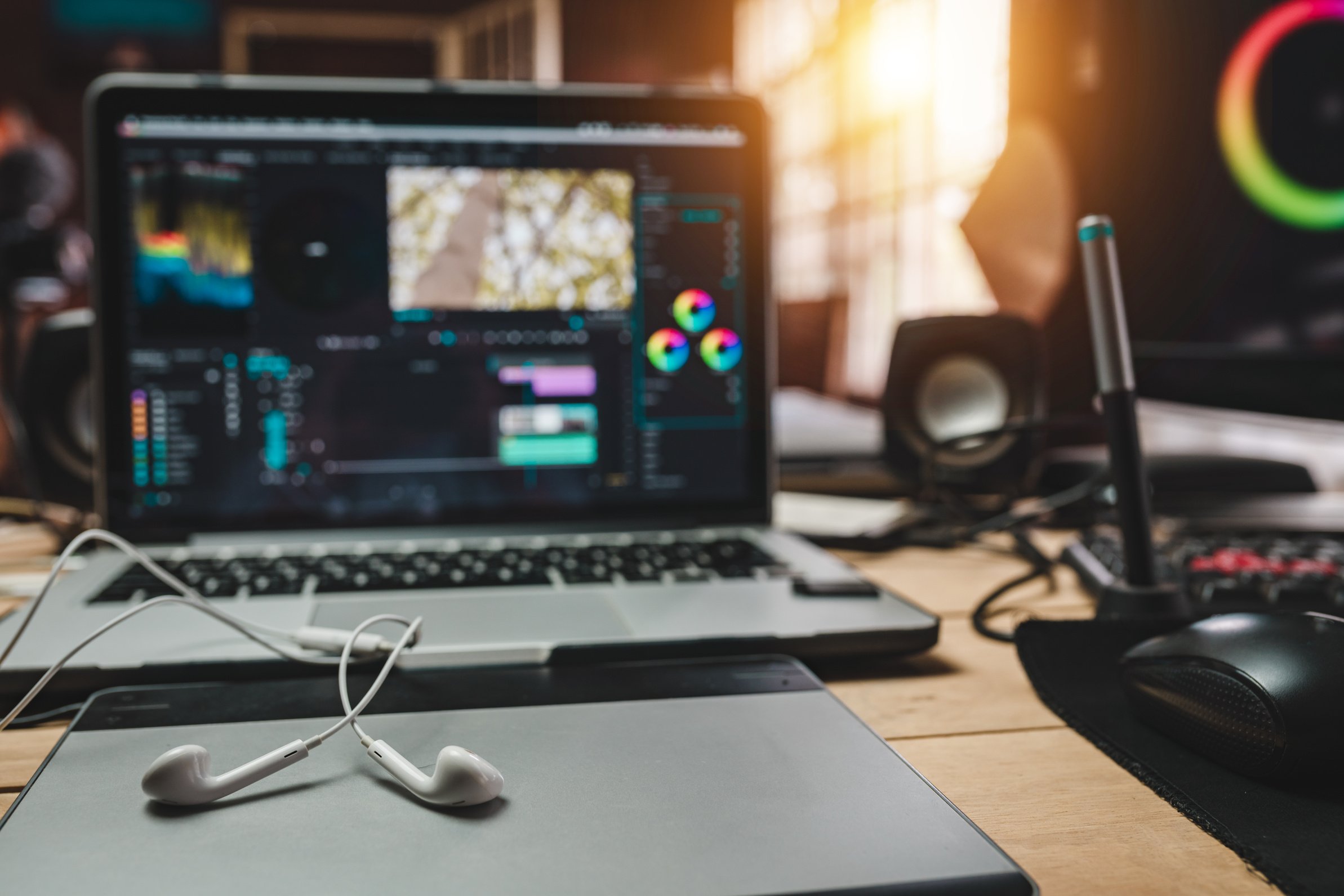 Desk work of the editor or content creator with headphones and the laptop for production content media